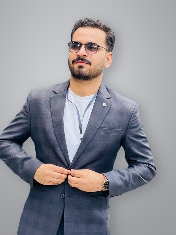Muhammad Alim Patujo in a grey suit and glasses